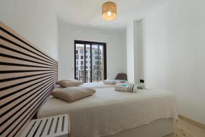 a white bedroom with a large bed with pillows at 327 marina duquesa in Manilva +58 photos