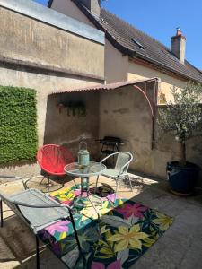 een patio met een tafel en stoelen en een tafel en stoelen bij L'Oiseau du paradis, entre gare et centre ville, rez-de-chaussée, avec terrasse et parking privé in Moulins