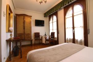 1 dormitorio con 1 cama y 1 mesa con sillas en Hotel Merindad de Olite, en Olite