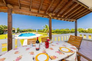 a table with a bottle of wine sitting on a patio at Villa Sunset Paradise in Kalavárda