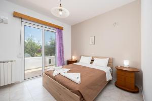 a bedroom with a large bed and a large window at Villa Sunset Paradise in Kalavárda +30 photos