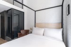 a bedroom with a large white bed and a chair at Walker Hotel Tribeca in New York