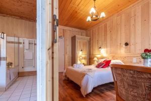 a bedroom with a bed in a room with wooden walls at Hôtel l'Hermitage in Brides-les-Bains