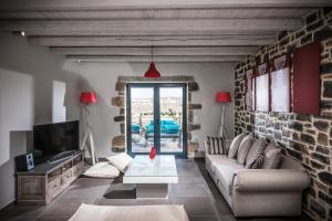 a living room with a couch and a tv at Anna Luxury Villa Cretevasion in Kokkíni Khánion