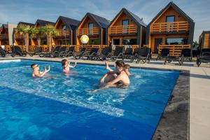 a group of people in the swimming pool at a resort at Ross-Domki in Sarbinowo