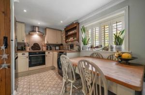 una cucina con tavolo e sedie in legno di A Beautiful Country Cottage a Waldringfield