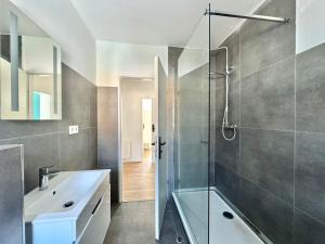 Un baño con ducha de cristal y lavabo. en Family Apartments Near City Centre, en Frankfurt