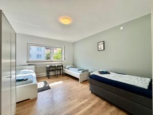 Un dormitorio con dos camas y una mesa dentro. en Family Apartments Near City Centre, en Frankfurt