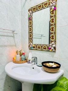 a bathroom with a sink and a mirror at Kale Stone Town Flat in Zanzibar City +53 photos