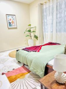 a bed in a room with a table and a window at Kale Stone Town Flat in Zanzibar City