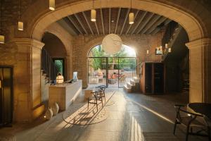 a building with an archway with tables and chairs at Can Aulí Luxury Retreat in Pollença