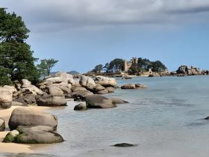 a body of water with rocks in the water at Petite Maison Cosy in Trégastel