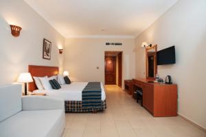 a hotel room with a bed and a desk at Le Jardin Aqua Park Resort in Hurghada