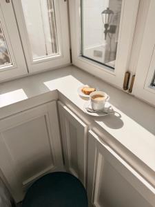 eine Tasse Kaffee und einen Teller Essen auf der Theke in der Unterkunft Apartamentos La Colonia de Muros in Muros de Nalón + 42 Fotos