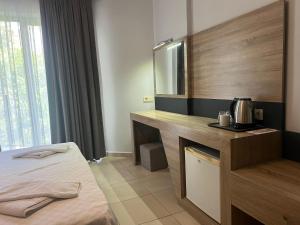 a hotel room with a bed and a sink and mirror at Club Palm Garden Keskin Hotel in Marmaris