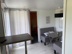 a living room with a table and a dining room at Bungalow à la campagne in Hautefage-la-Tour