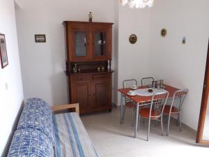 カーラゴノネにあるApartment Cala Gonone Beachのテーブルと椅子、ベッドルーム1室が備わります。