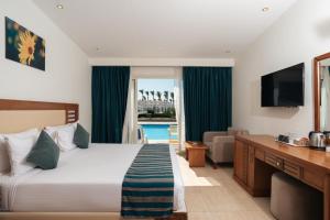 a hotel room with a large bed and a television at Le Jardin Aqua Park Resort in Hurghada +41 photos