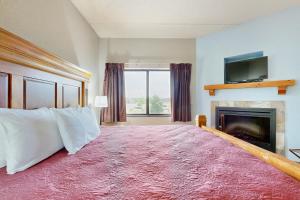 a bedroom with a large bed with a fireplace at Chula Vista Condo 2344 and 2346 in Wisconsin Dells