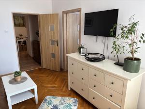 a living room with a dresser with a television on it at Apartamenty Stare Miasto Boho Parking in Nowy Sącz