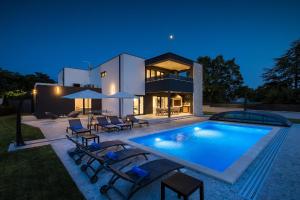 a house with a swimming pool at night at Villa dell Re in Žminj