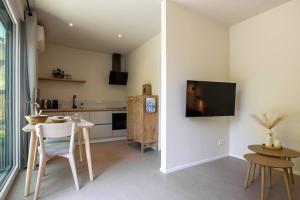 オーストカペッレにあるNEW Hello Zeeland - Magnolialaan 2のキッチン(テーブル付)、壁掛けテレビ