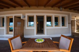 un cesto di frutta su un tavolo di legno con sedie di Loryma Luxury Hotel Bozburun a Bozburun