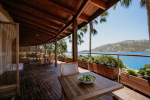 un ponte di legno con una ciotola di frutta su un tavolo di Loryma Luxury Hotel Bozburun a Bozburun