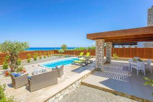 a backyard with a swimming pool and a wooden fence at Villa Ira in Lachania