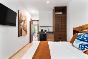 a bedroom with a large bed with a television on the wall at Eclectic Akumal Retreat Pool Beach Wi-Fi Tulum in Tankah +32 photos