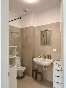 a bathroom with a sink and a toilet at Flower Cozy Flat at Santorini Resort in Himare