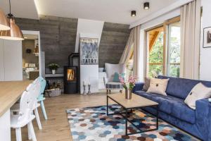 un salon avec un canapé bleu et une table dans l'établissement Miedziane Turnie apartment, à Zakopane