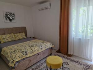 a bedroom with a bed and a stool and a window at Holiday house Ogi in Bar