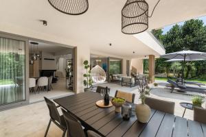 a dining room and living room with a table and chairs at Villa Boschetto by SeeAdria Agency in Čepljani