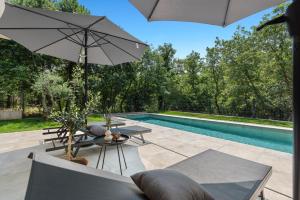 a patio with an umbrella and a swimming pool at Villa Boschetto by SeeAdria Agency in Čepljani