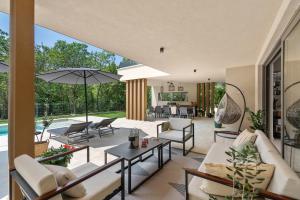 an open living room with a patio and a pool at Villa Boschetto by SeeAdria Agency in Čepljani