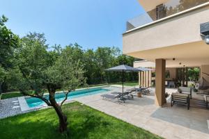 a backyard with a swimming pool and a house at Villa Boschetto by SeeAdria Agency in Čepljani