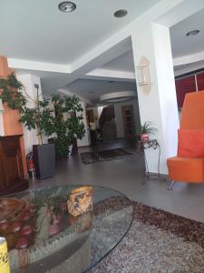 a living room with a glass table and an orange chair at Crystal Aura in Paralia Katerinis +29 photos
