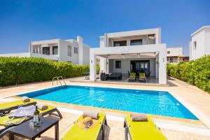 a villa with a swimming pool in front of a house at Villa Metis in Lachania