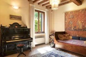 a living room with a piano and a couch at VILLA VALCHERO 12, Emma Villas in Carpaneto Piacentino +38 photos