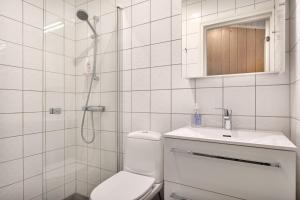a bathroom with a shower and a toilet and a sink at Bitigrenda M in Beitostøl