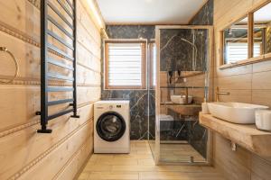 a bathroom with a washing machine and a sink at DOMEK Z BALA ELITA in Kościelisko +37 photos