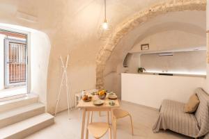 una sala de estar con una mesa y un sofá en Acquasale Apartments - L'Ulivo by BarbarHouse, en Vieste