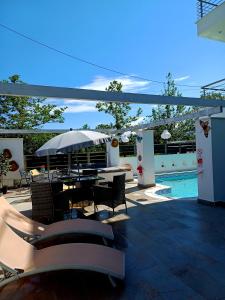 a patio with a table and chairs and an umbrella at Crystal Aura in Paralia Katerinis