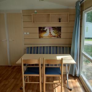 ein Esszimmer mit einem Tisch und zwei Stühlen in der Unterkunft Smart Home Paris mit Terrasse, Europapark, Rulantica in Boofzheim