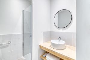 a white bathroom with a sink and a mirror at La Résidence Inco in Saint-Bertrand-de-Comminges