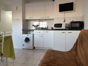 a kitchen with a washing machine and a microwave at Appartement Studio à Saint Pierre la Mer près de la plage - FR-1-229D-149 in Fleury +9 photos
