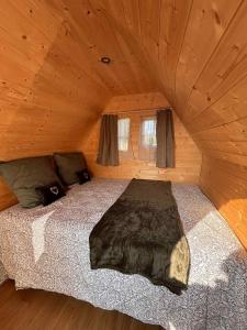 a bedroom with a bed in a wooden cabin at La Cabane Mini Enchantée ! in Thenay