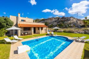a villa with a swimming pool in front of a house at Villa Hara Faragi in Giannoudi