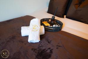 un lit avec une serviette et un panier de produits de toilette dans l'établissement Luxury 2 Bedroom 2 Bathroom Apartment In Wimbledon, à New Malden 42 autres photos